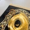 لقطة مقربة لسجادة صلاة باللونين الأسود والذهبي مع سبحة خشبية